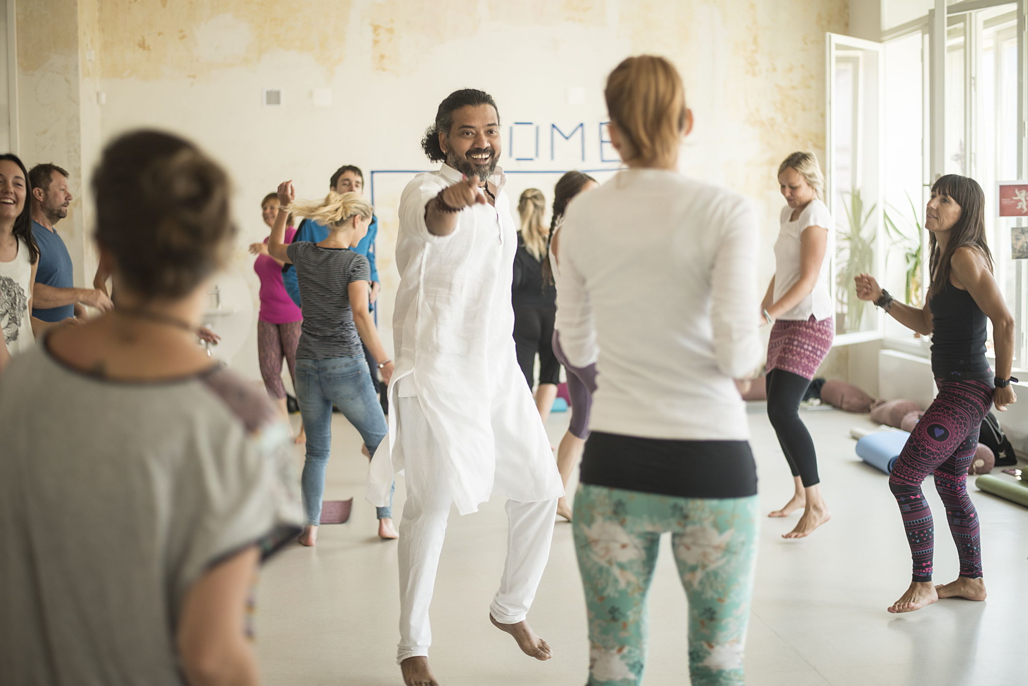 Yogalehrer Kabir Bharti mit einer Gruppe an Yogateilnehmern, die fröhlich tanzen