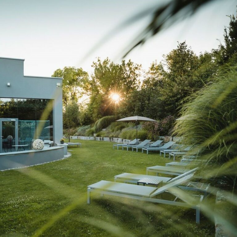 Garten Eden mit Einzelliege und Sonnenschirm in der Dämmerung