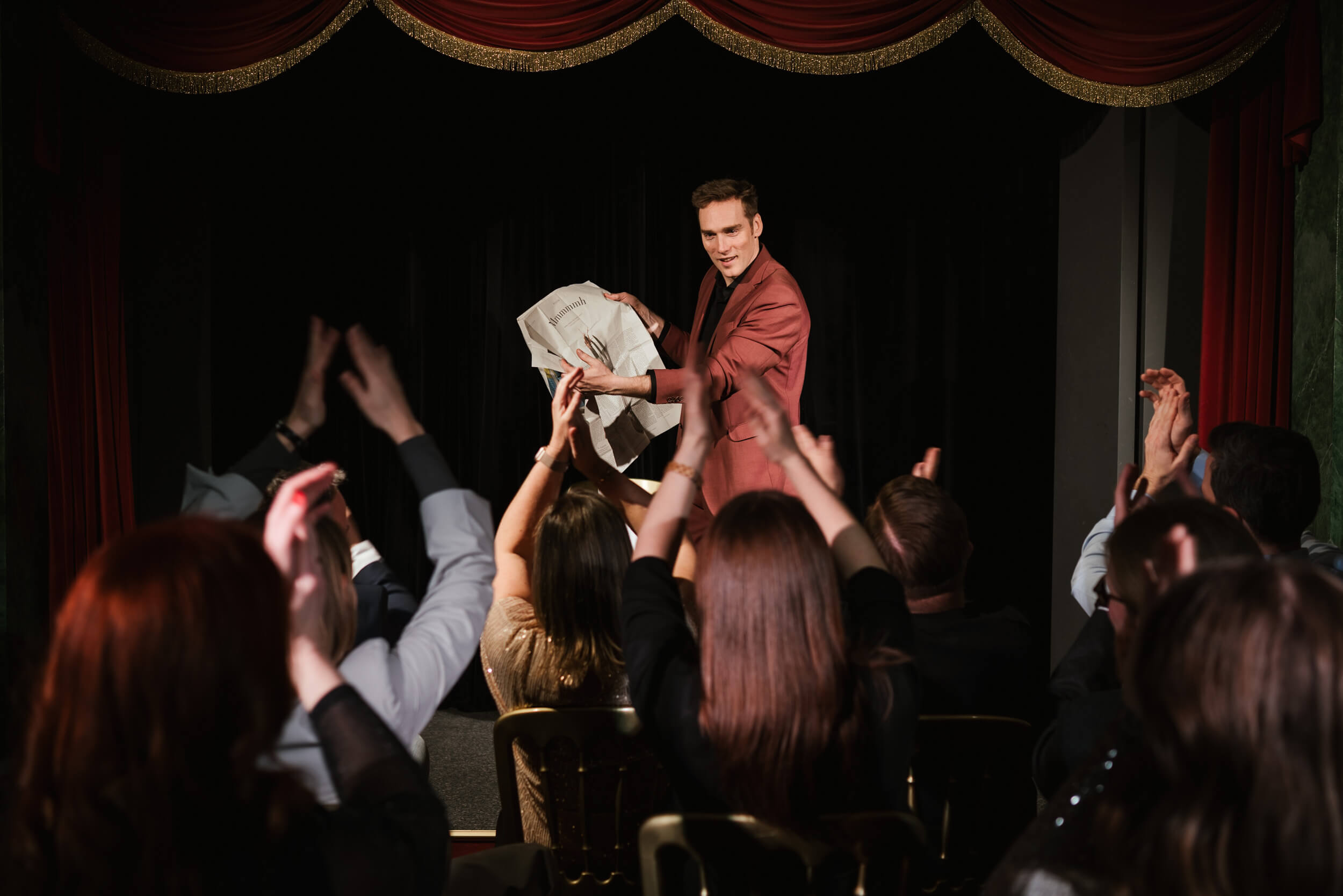 Magier auf der Bühne zeigt Zeitung